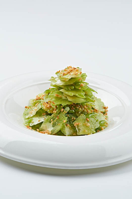 白色瓷盘装的蒜沫凉拌苦瓜片图片