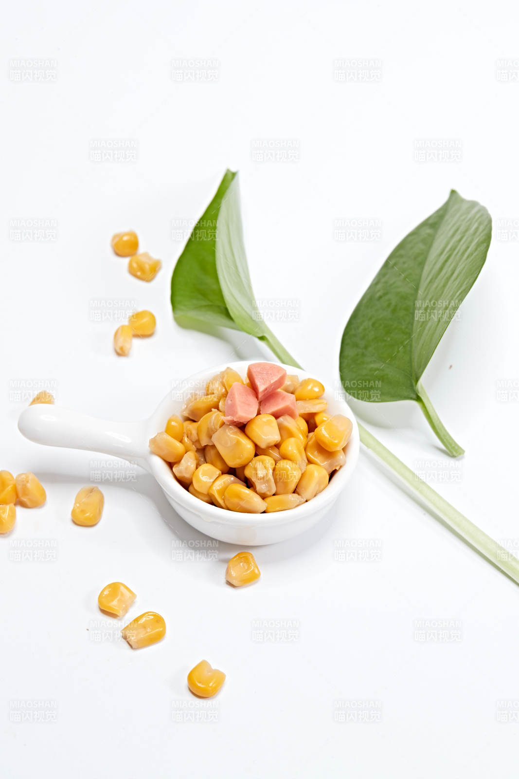 白色背景上的甜玉米粒图片