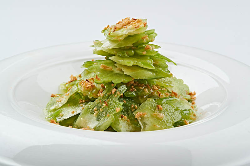 白色瓷盘装的蒜沫凉拌苦瓜片图片