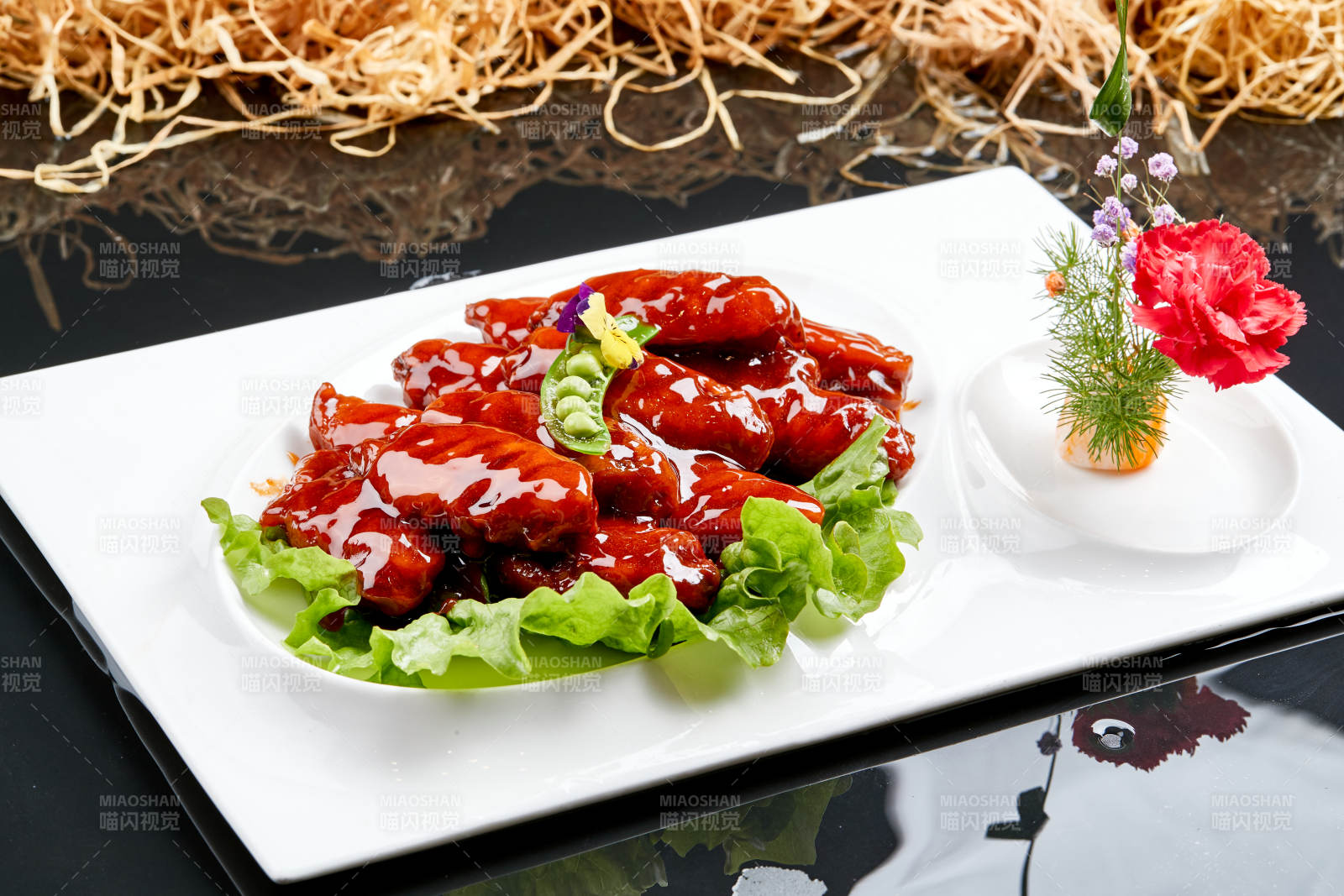 白色瓷盘装的蜜豆酱鸡翅中图片