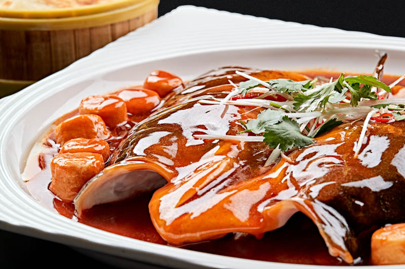 白色瓷盘装的红烧千岛湖大鱼头图片