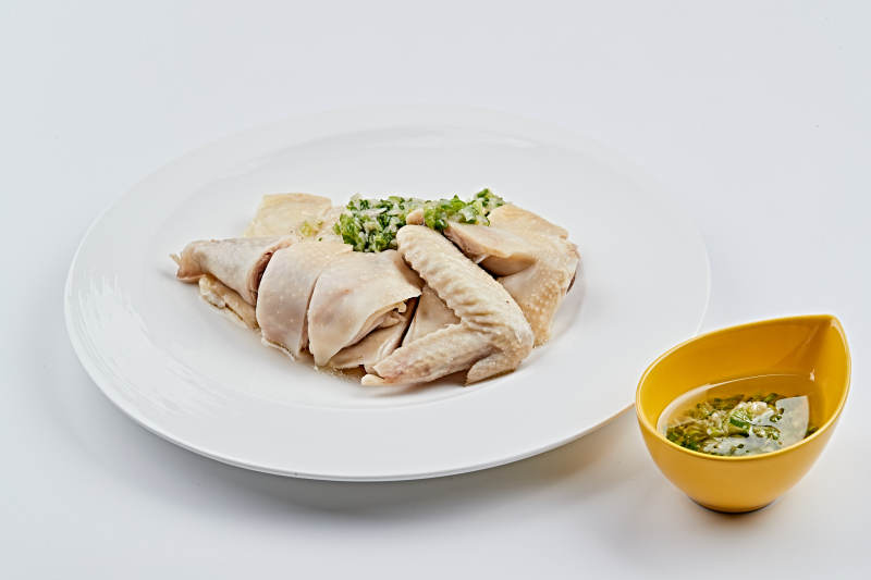 白色盘装的广式蘸汁白切鸡图片