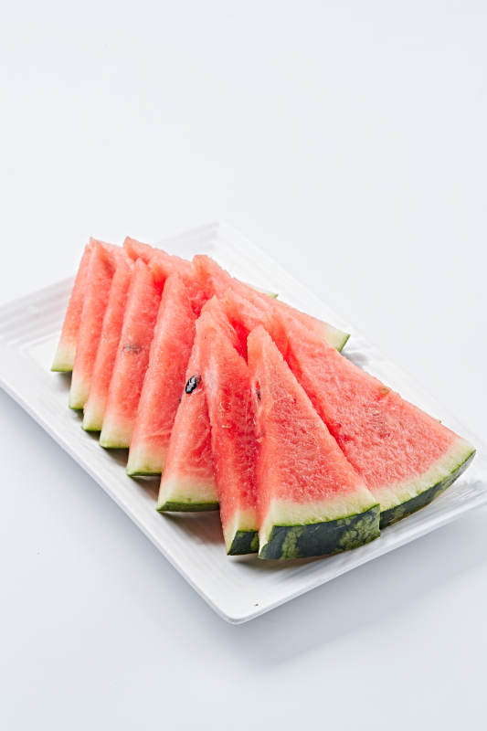 白色瓷盘装的切好的西瓜图片