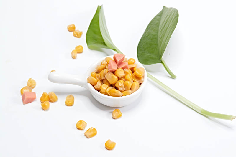 白色背景上的甜玉米粒图片