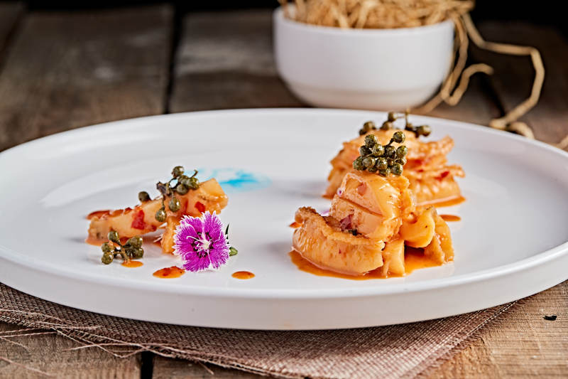 白色瓷盘装的藤椒鸡汁小鲍鱼图片