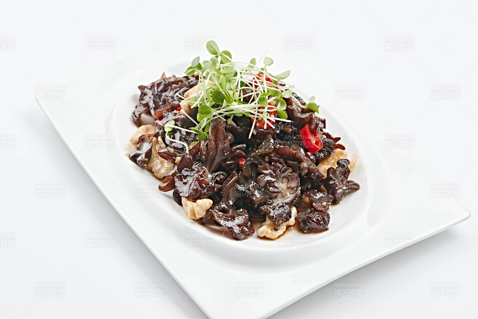 白色瓷盘装的桃仁猴头菌图片