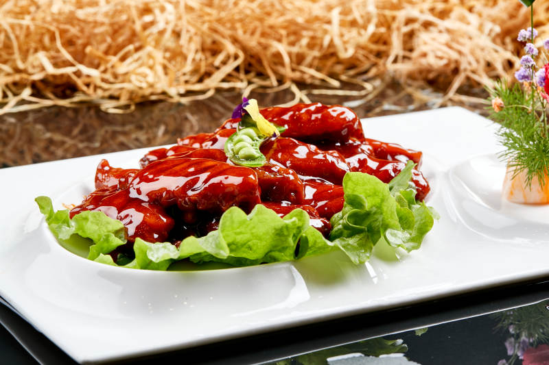 白色瓷盘装的蜜豆酱鸡翅中图片