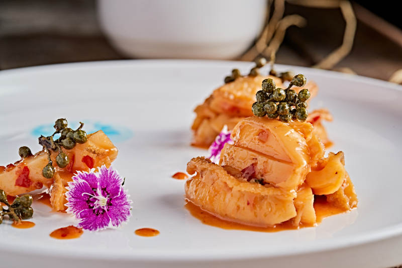 白色瓷盘装的藤椒鸡汁小鲍鱼图片