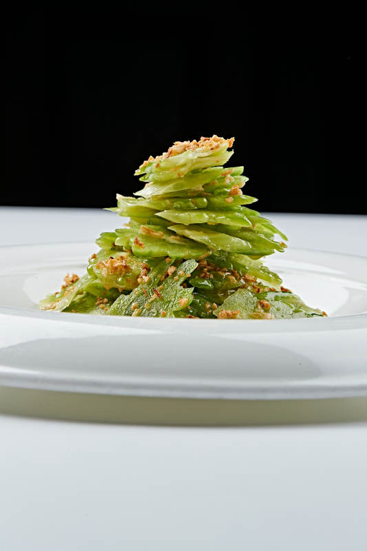 白色瓷盘装的蒜沫凉拌苦瓜片图片