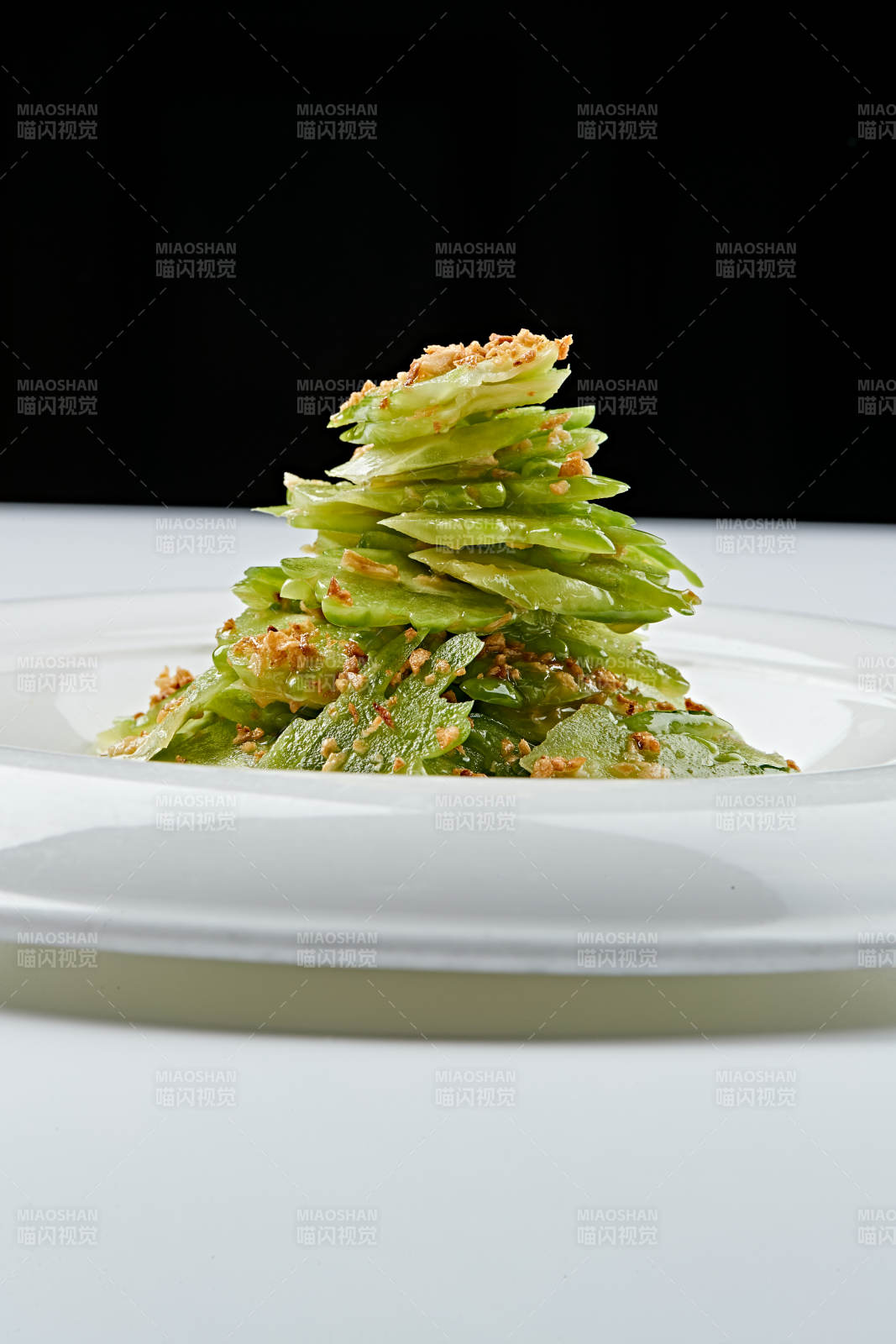 白色瓷盘装的蒜沫凉拌苦瓜片图片