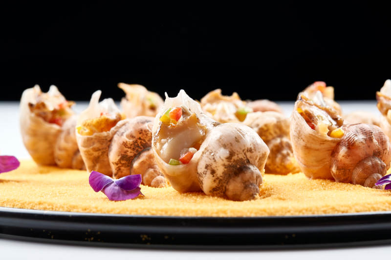 精美装饰餐具装的盐烧小海螺图片