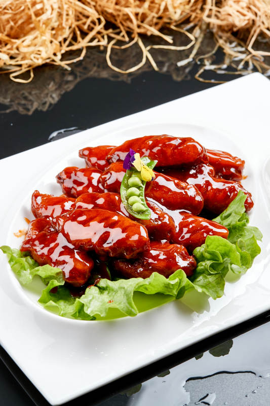 白色瓷盘装的蜜豆酱鸡翅中图片