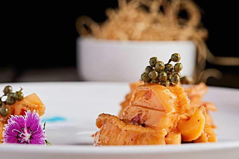 白色瓷盘装的藤椒鸡汁小鲍鱼图片