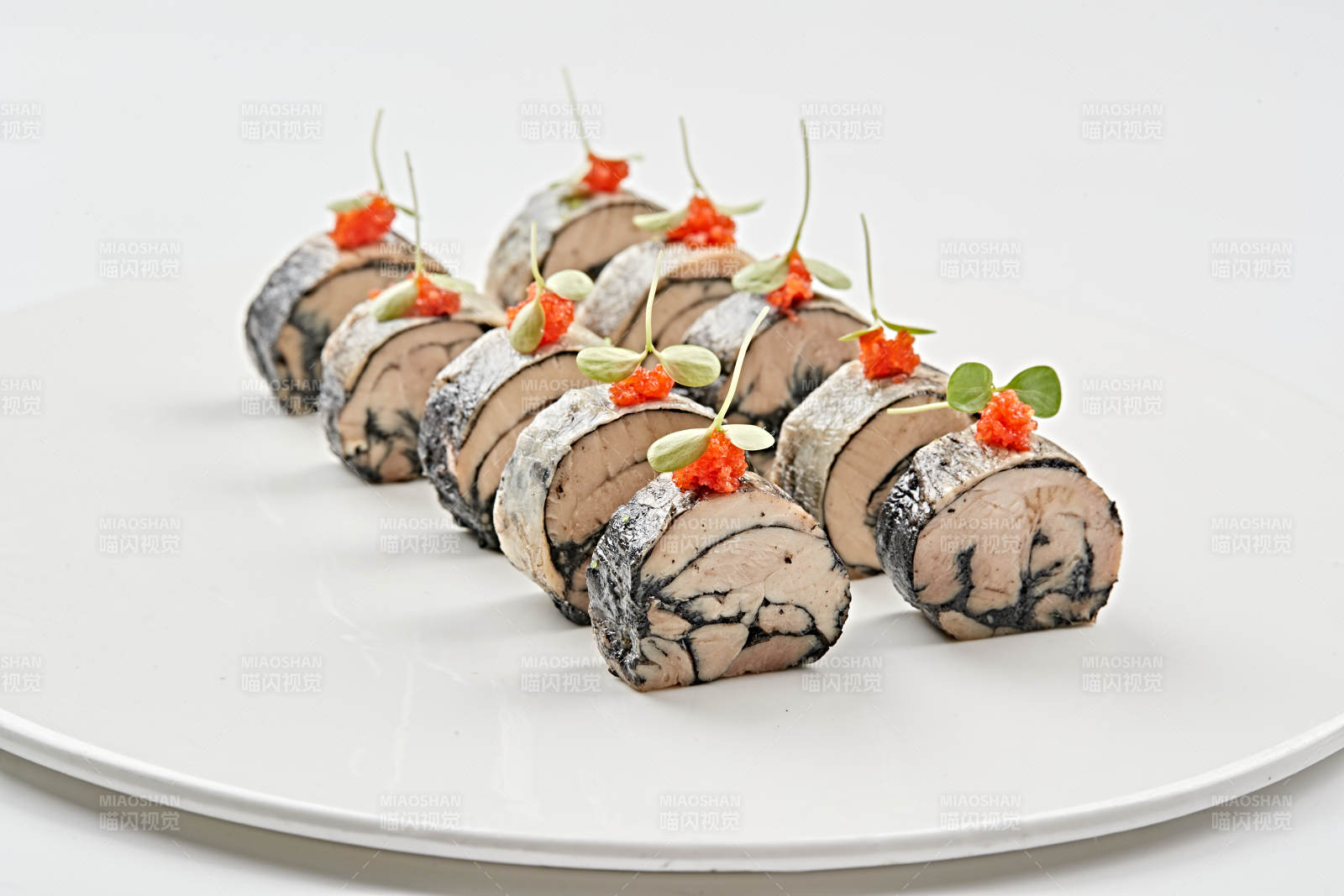 白色瓷盘装的压海苔金枪鱼卷切片图片