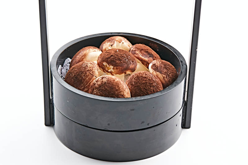 古典木质食盒装的可可粉香菇豆沙包图片