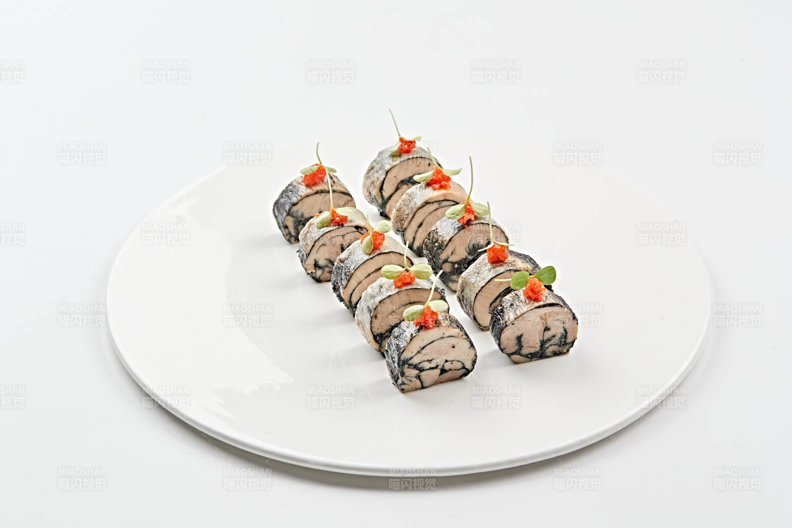 白色瓷盘装的压海苔金枪鱼卷切片图片
