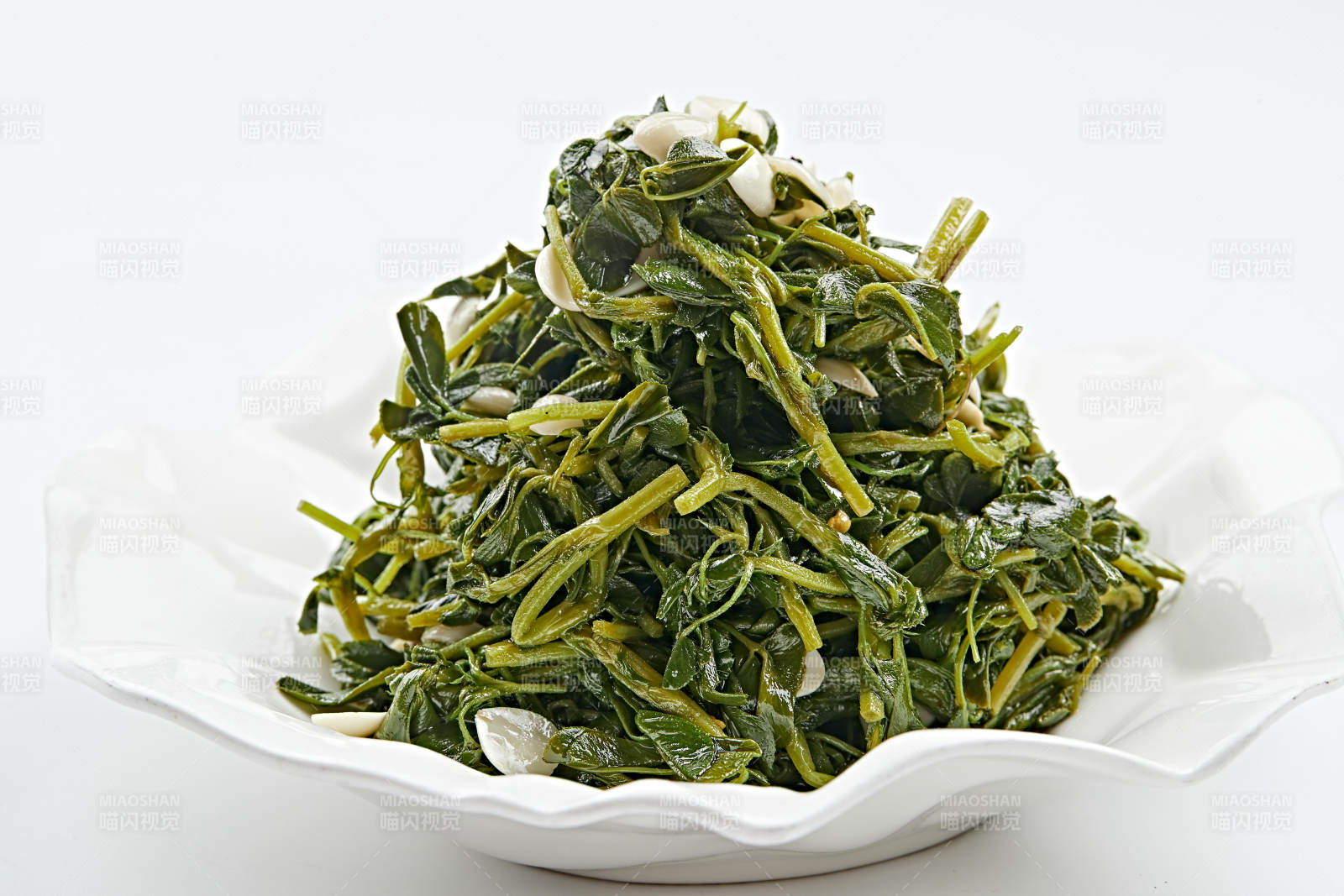 白色瓷盘装的杏仁炝拌野菜图片