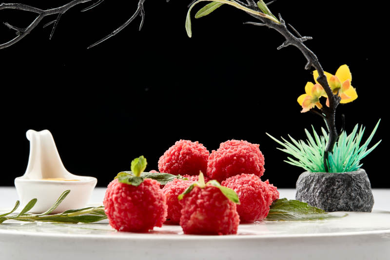 白瓷盘装的精美摆盘的荔枝大虾球图片