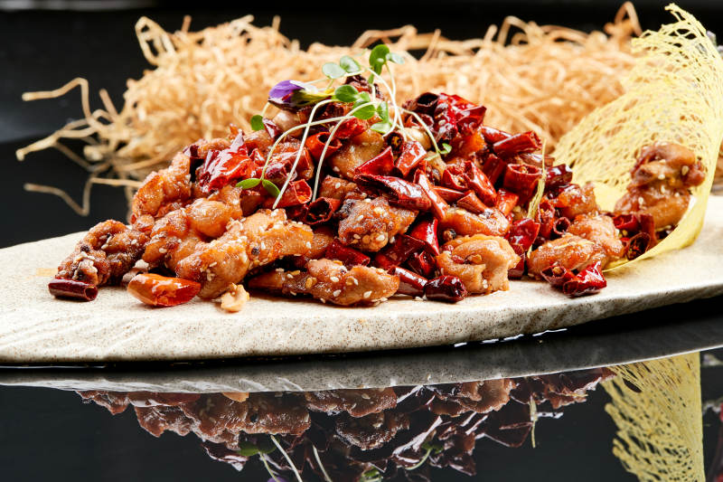 精美餐具装的香辣豆苗鸡腿肉图片