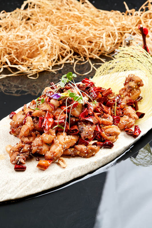 精美餐具装的香辣豆苗鸡腿肉图片