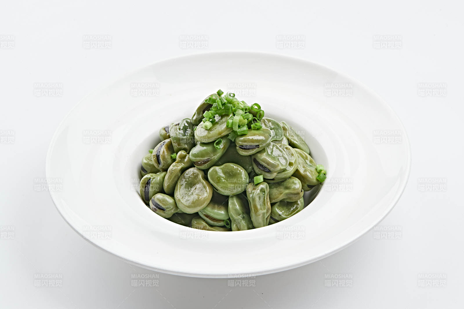 白色瓷盘装的腌渍蚕豆图片