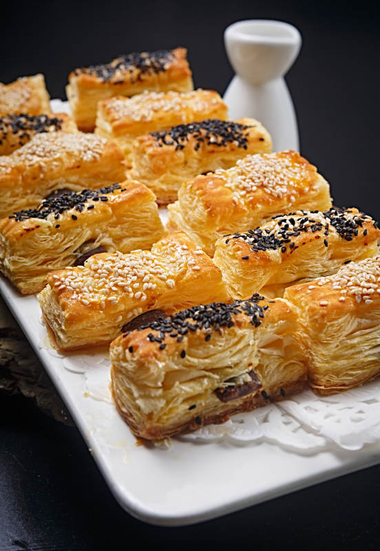 半打榴莲酥摆放在黑色背景上图片