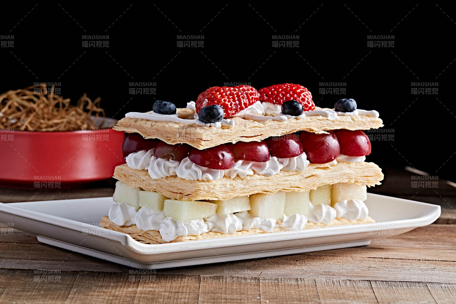 白色瓷盘装的水果戚风奶油拿破仑蛋糕图片