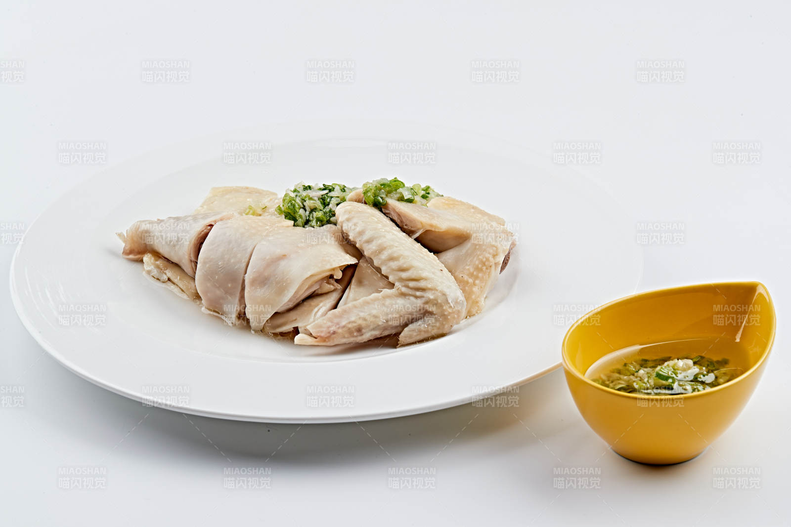 白色盘装的广式蘸汁白切鸡图片