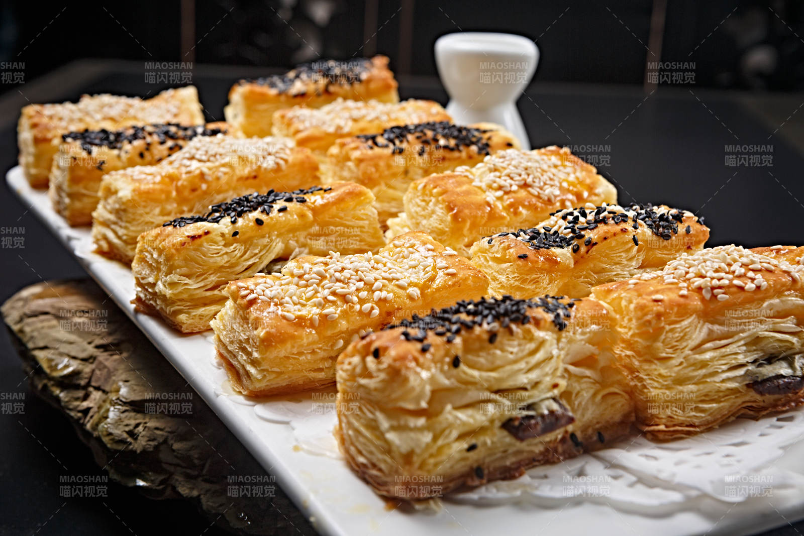 半打榴莲酥摆放在黑色背景上图片