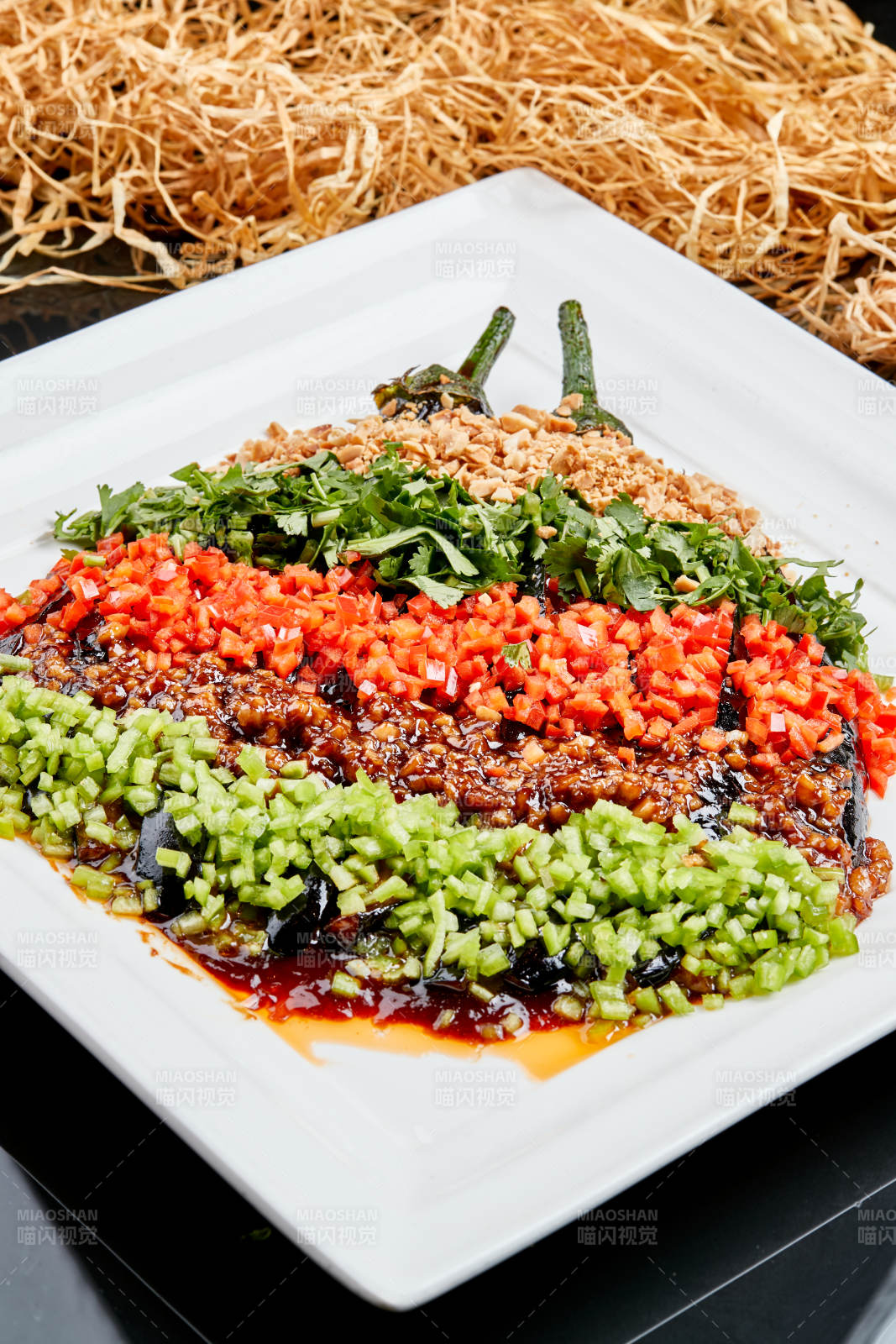 白色瓷盘装的酱香五色蒜泥茄子图片