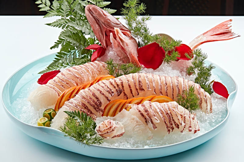 布满碎冰的青色瓷盘装的鲷鱼刺身生鱼片图片