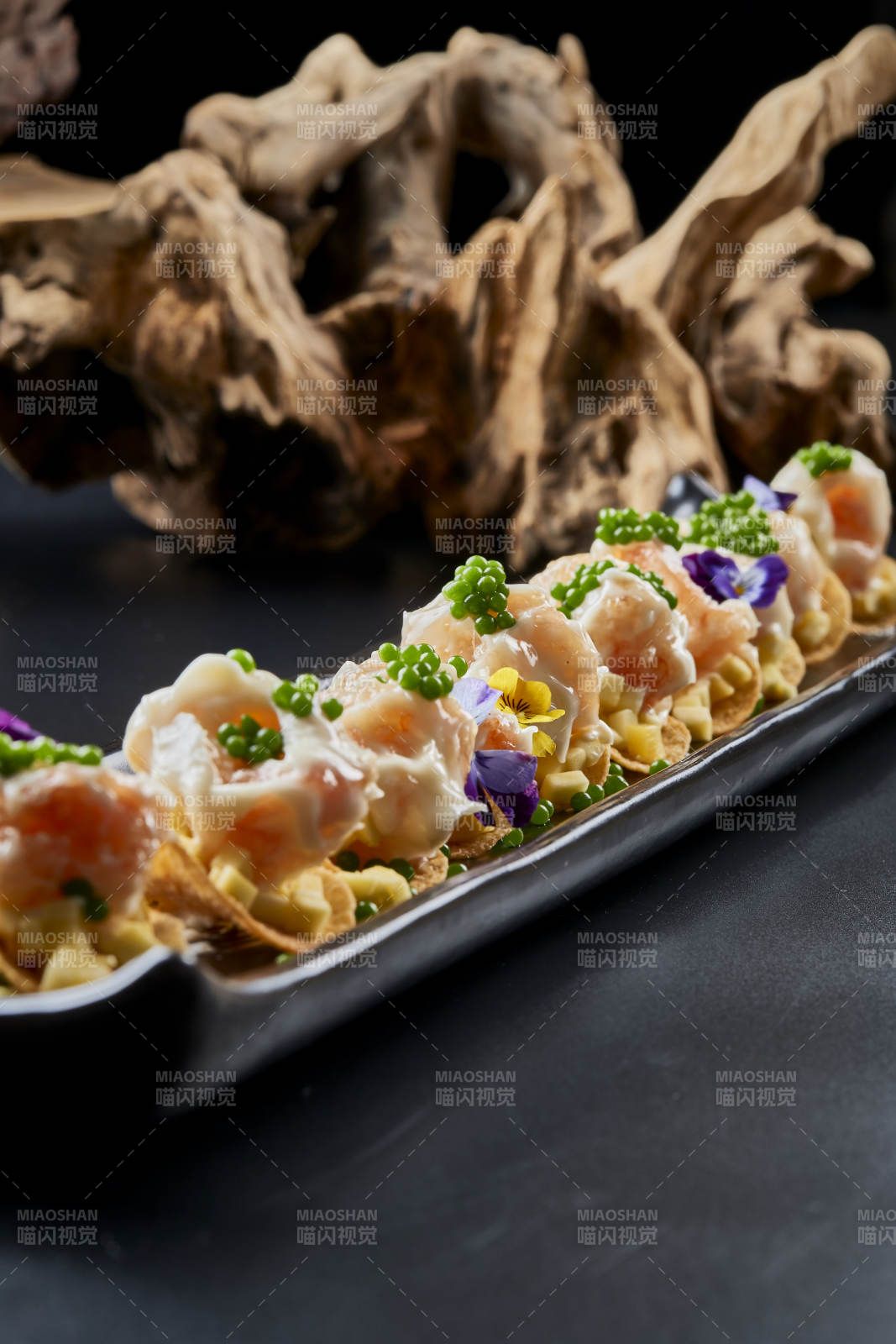 黑色长瓷盘装的青鱼子奶香芝士薯片焗虾仁图片