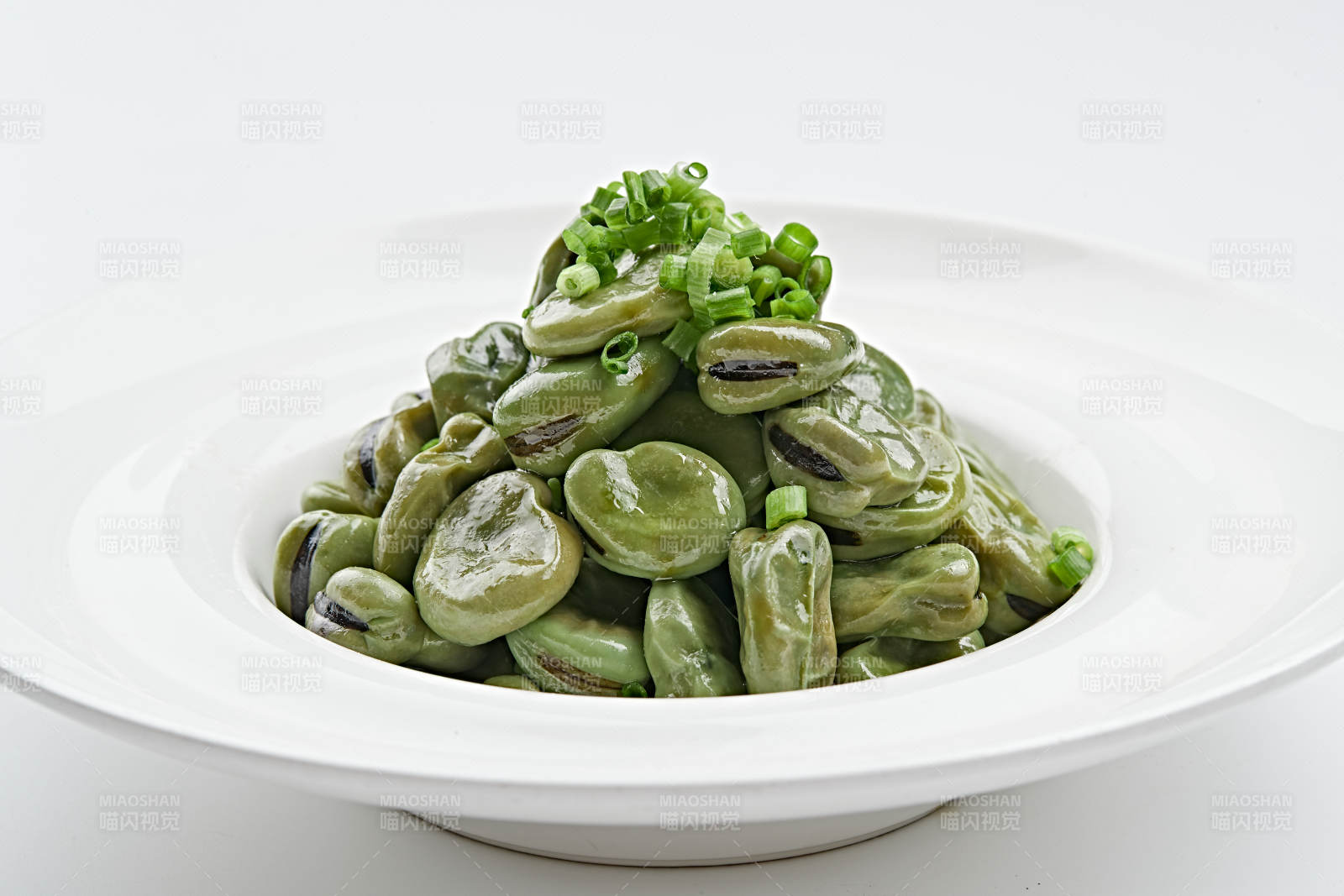 白色瓷盘装的腌渍蚕豆图片
