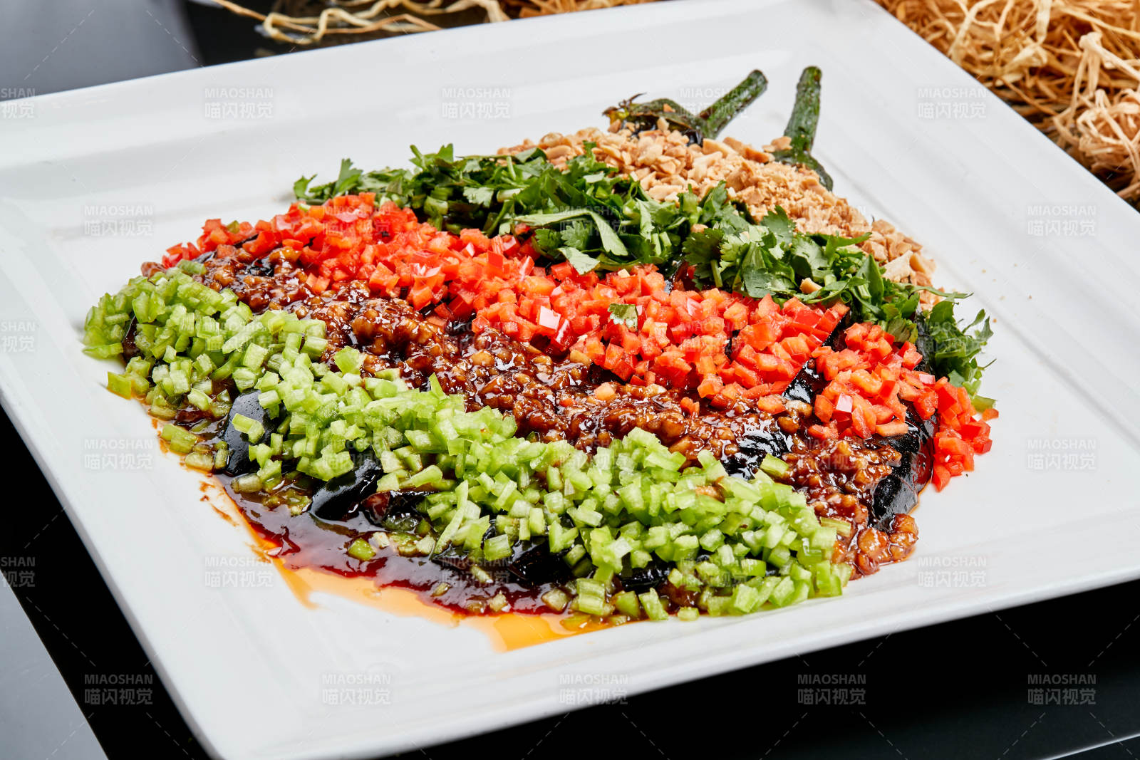 白色瓷盘装的酱香五色蒜泥茄子图片