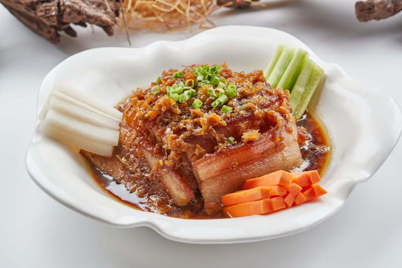 白色瓷餐具装的梅菜扣肉图片