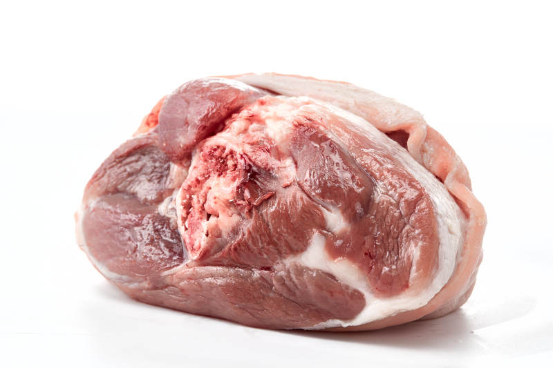 白色背景下的生鲜猪肘子图片