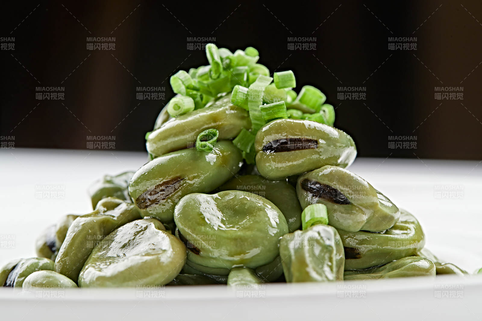 白色瓷盘装的腌渍蚕豆图片