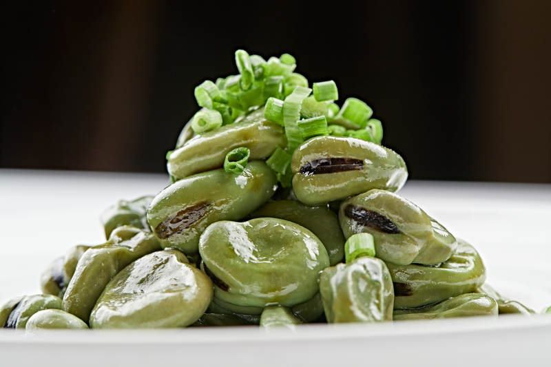 白色瓷盘装的腌渍蚕豆图片