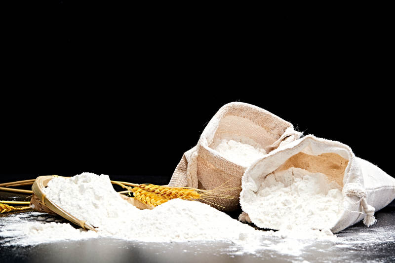 黑色背景上的粗粮荞麦面粉图片