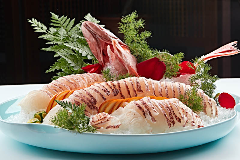 布满碎冰的青色瓷盘装的鲷鱼刺身生鱼片图片