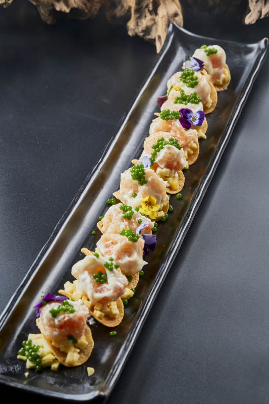 黑色长瓷盘装的青鱼子奶香芝士薯片焗虾仁图片