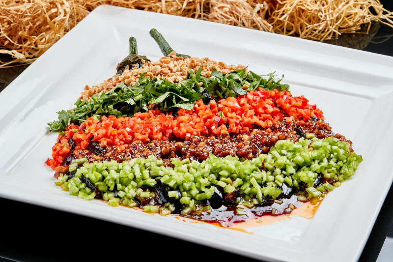 白色瓷盘装的酱香五色蒜泥茄子图片