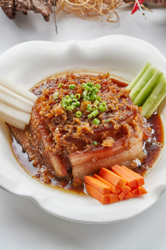 白色瓷餐具装的梅菜扣肉图片