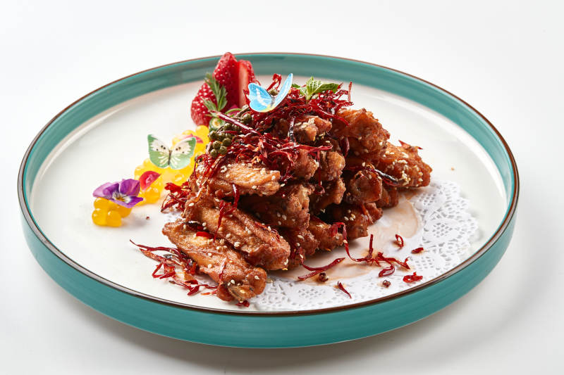 精美瓷餐具装的川味香辣炸鸡翅图片