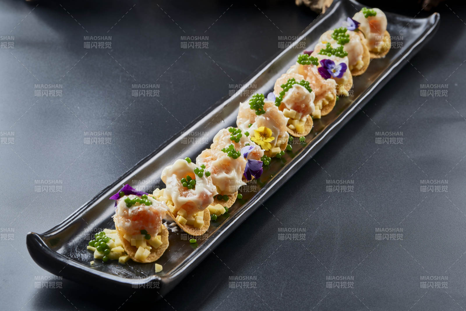 黑色长瓷盘装的青鱼子奶香芝士薯片焗虾仁图片