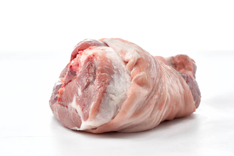 白色背景下的生鲜猪肘子图片