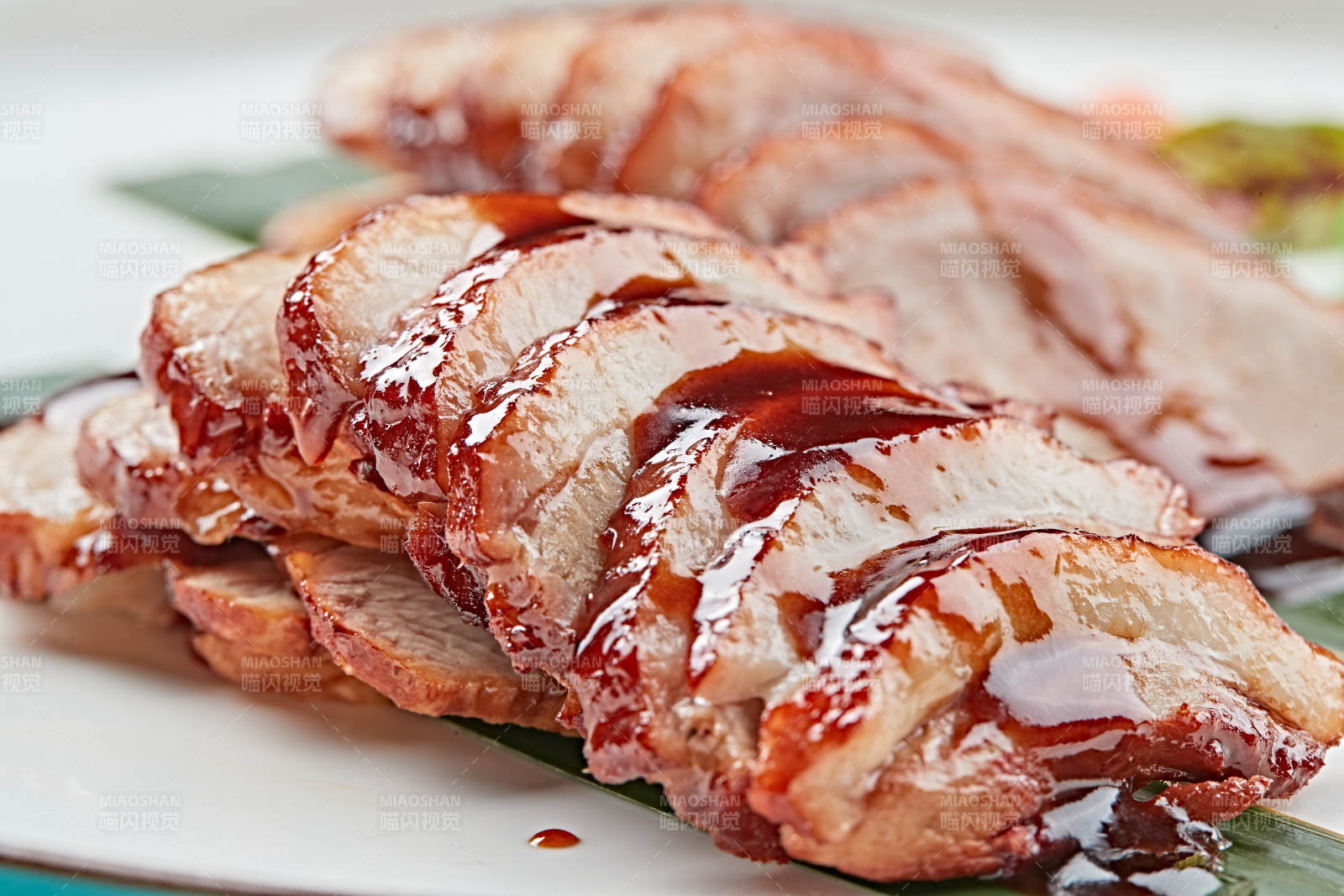 白色瓷盘装的烟熏鸭胸肉切片图片