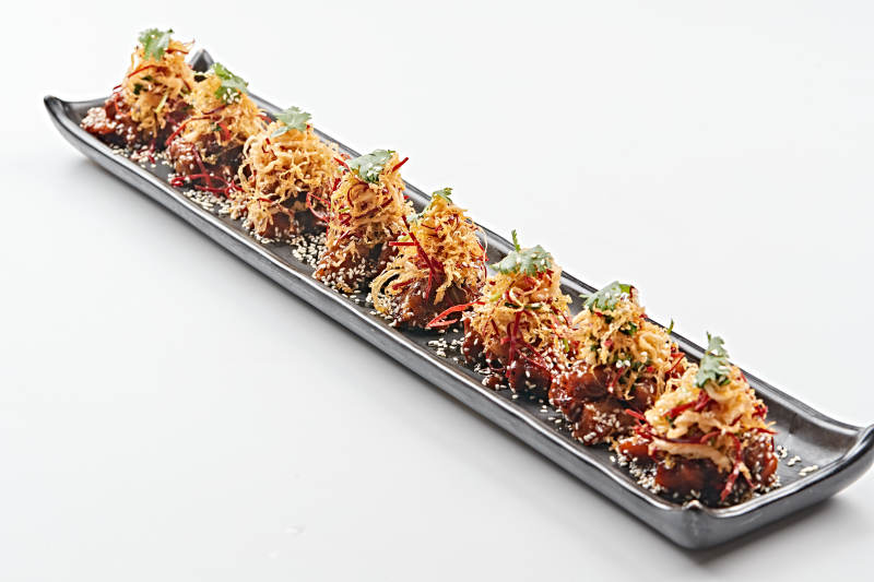 黑色长石盘装的油炸酸菜猪月牙骨图片