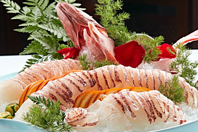 布满碎冰的青色瓷盘装的鲷鱼刺身生鱼片图片