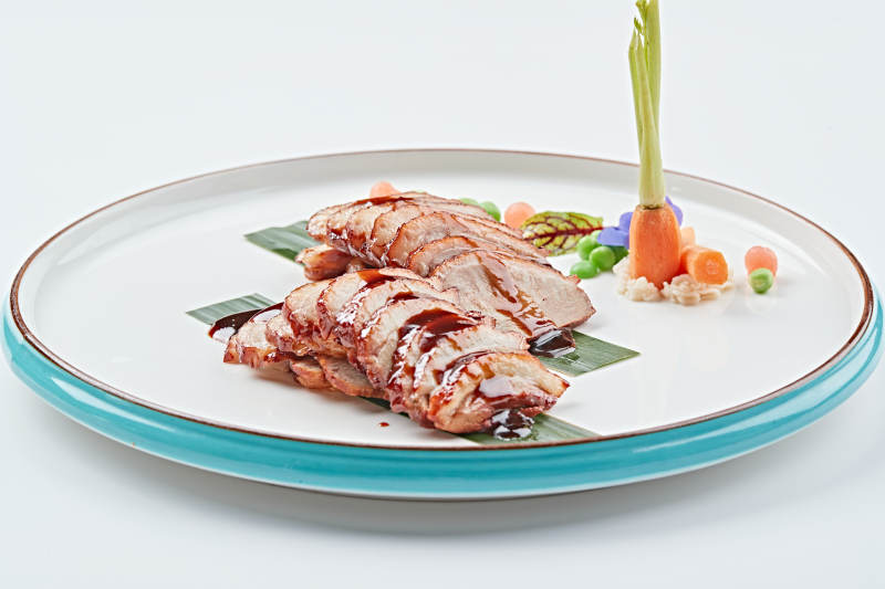 白色瓷盘装的烟熏鸭胸肉切片图片